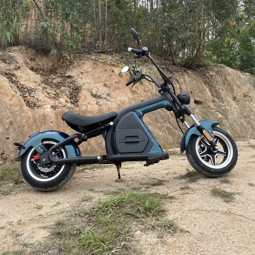 Mangosteen M8 Citycoco Scooter in Rubin Grün, geparkt vor einem felsigen Hintergrund, zeigt das stilvolle Design und die robuste Bauweise.