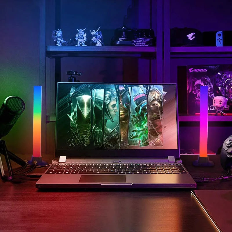 RGB-LED-Lichter auf einem Schreibtisch neben einem Gaming-Laptop, mit farbenfroher Beleuchtung für ein Gaming-Setup.