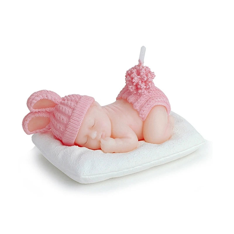 Schlafende Baby-Kerze in Rosa mit Hasenohren und Bommel-Hose, dekorativ auf einem Kissen präsentiert.